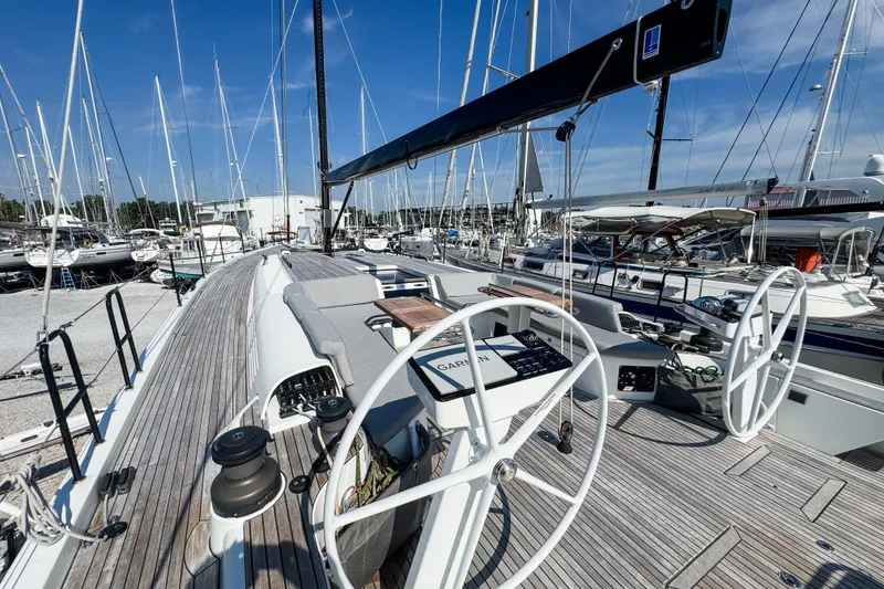 Slide: The Image of 2024 Beneteau First 53 sailboat with dual steering wheels in a marina setting. - 5