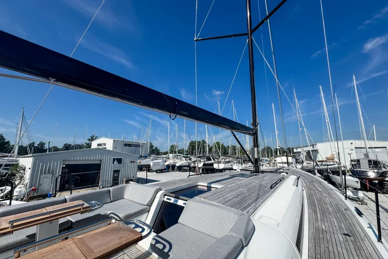 Slide: The Image of 2024 Beneteau First 53 yacht docked at marina under clear blue sky. - 9