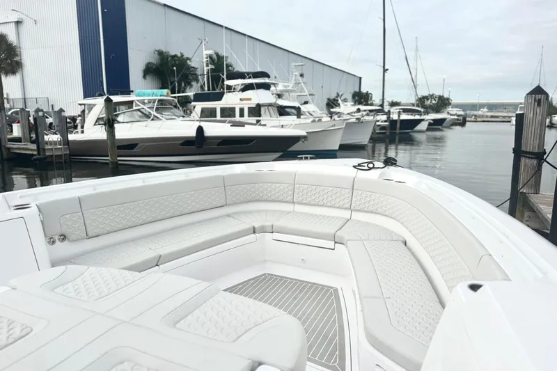 Slide: The Image of 2025 Intrepid 51 Panacea luxury boat docked at marina with sleek seating area. - 8