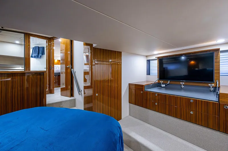 Slide: The Image of Luxurious bedroom interior of 2018 Maritimo M54 yacht with blue bedding and wooden accents. - 70