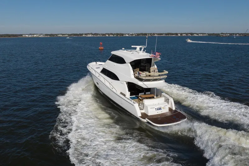 Slide: The Image of 2018 Maritimo M54 yacht cruising on open water, rear view with wake. - 97