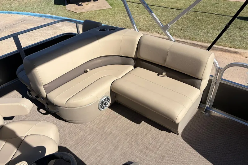 Slide: The Image of 2024 Sun Tracker Party Barge 18 DLX interior with beige seating and cup holders. - 22