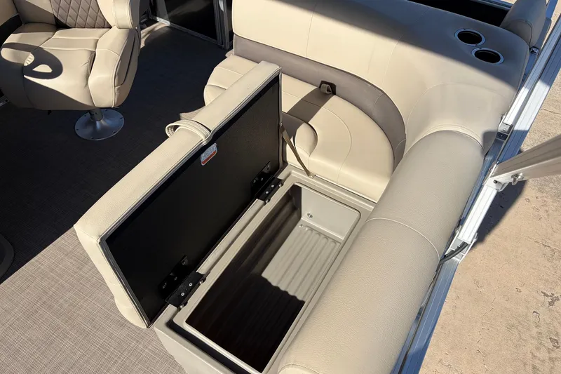 Slide: The Image of 2024 Sun Tracker Party Barge 18 DLX interior with open storage compartment and seating. - 23