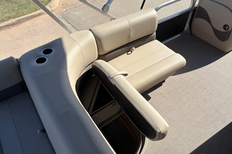 Slide: The Image of 2024 Sun Tracker Party Barge 18 DLX interior with beige seating and cup holders. - 24