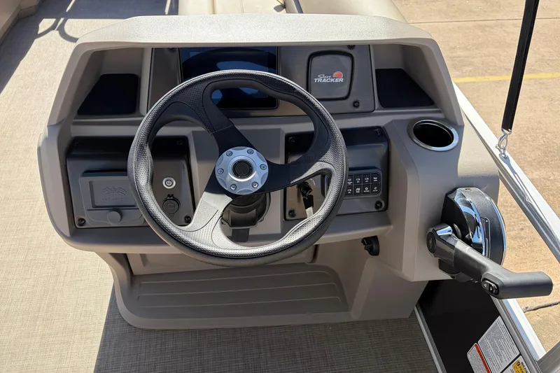 Slide: The Image of 2024 Sun Tracker Party Barge 18 DLX steering console with controls and cup holder. - 27