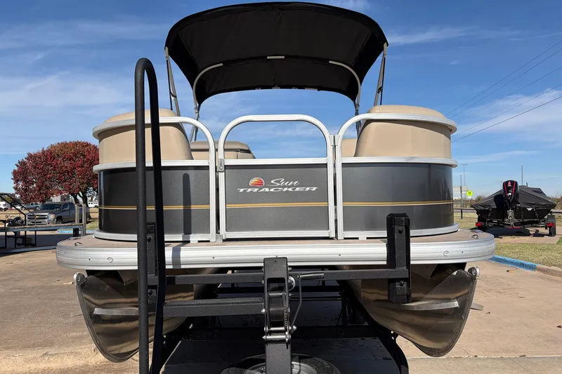 Slide: The Image of 2024 Sun Tracker Party Barge 18 DLX pontoon boat on trailer, outdoor setting. - 3