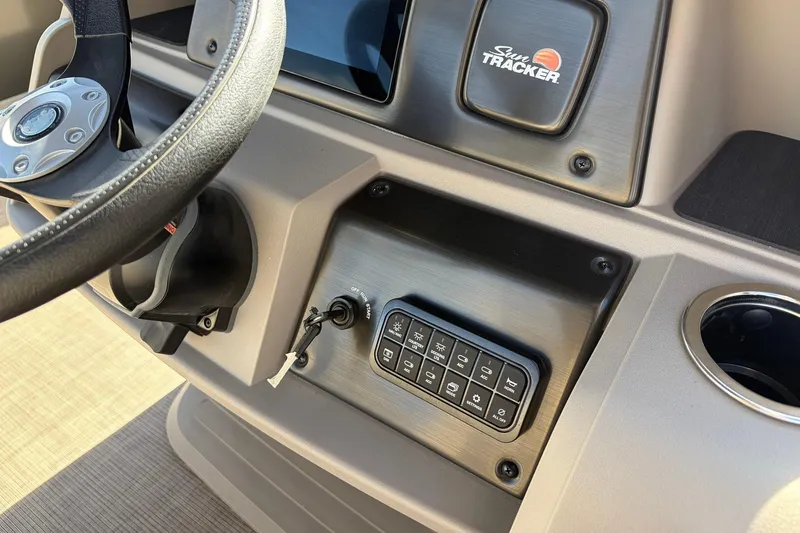 Slide: The Image of 2024 Sun Tracker Party Barge 18 DLX dashboard with steering wheel and control panel. - 30