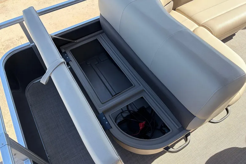 Slide: The Image of 2024 Sun Tracker Party Barge 18 DLX storage compartment with open seat revealing interior space. - 34