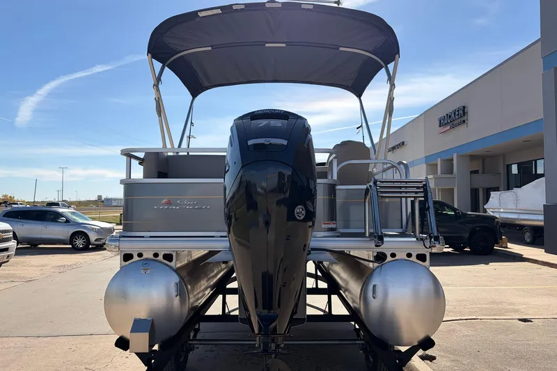 Slide: The Image of 2024 Sun Tracker Party Barge 18 DLX pontoon boat with outboard motor, parked outdoors. - 7