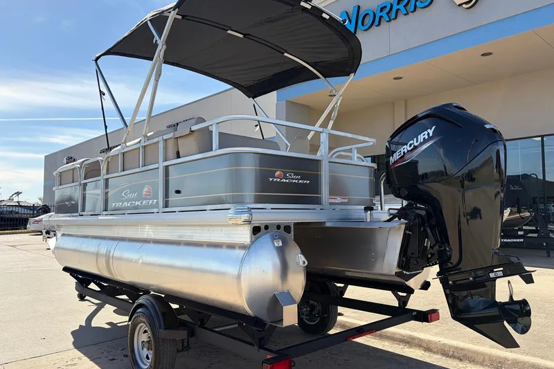 Slide: The Image of 2024 Sun Tracker Party Barge 18 DLX pontoon boat with Mercury engine, parked outdoors. - 8