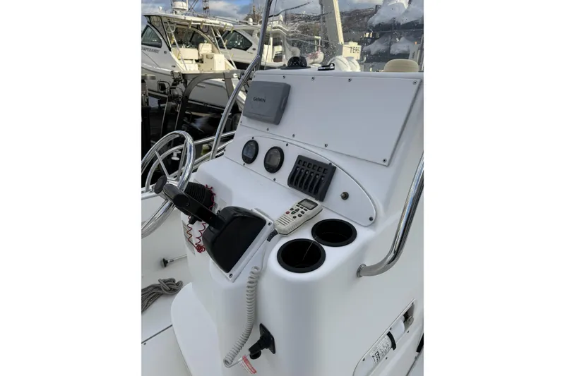Slide: The Image of 2004 Boston Whaler 190 Nantucket boat console with steering wheel and navigation equipment. - 11