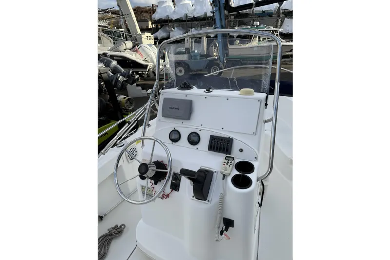Slide: The Image of 2004 Boston Whaler 190 Nantucket boat console with steering wheel and navigation equipment. - 12