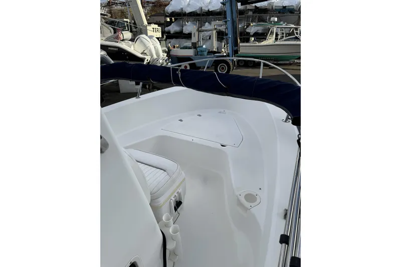 Slide: The Image of 2004 Boston Whaler 190 Nantucket boat interior with seating and storage, docked in a marina. - 15