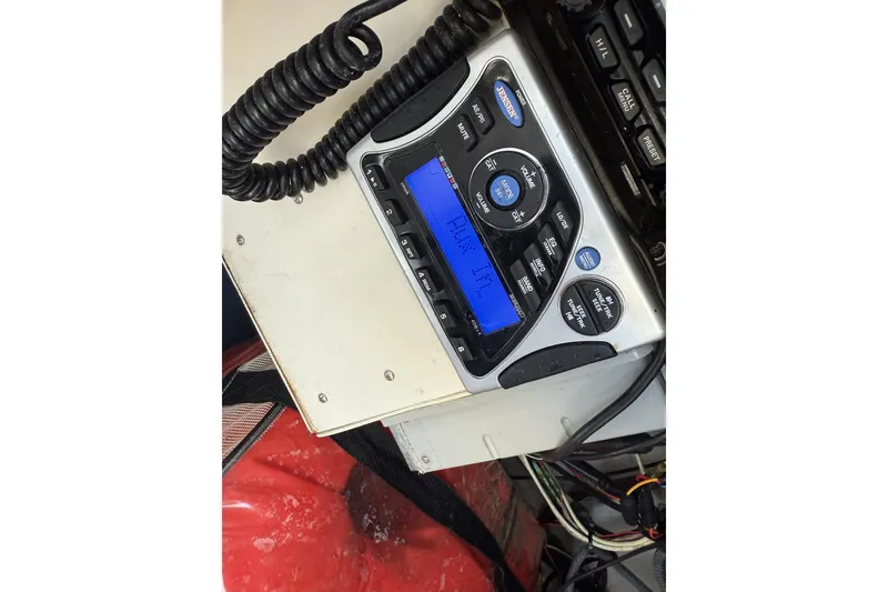 Slide: The Image of 2004 Boston Whaler 190 Nantucket boat radio system with blue display and controls. - 18