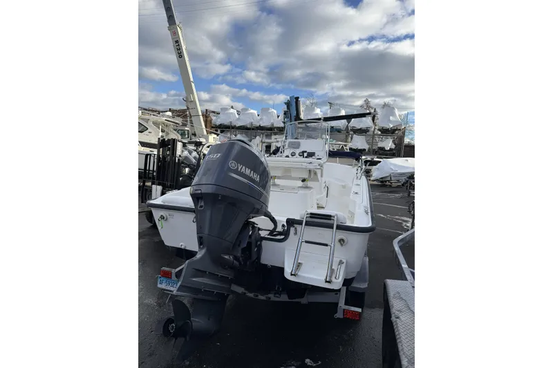 Slide: The Image of 2004 Boston Whaler 190 Nantucket boat with Yamaha engine in a marina setting. - 2