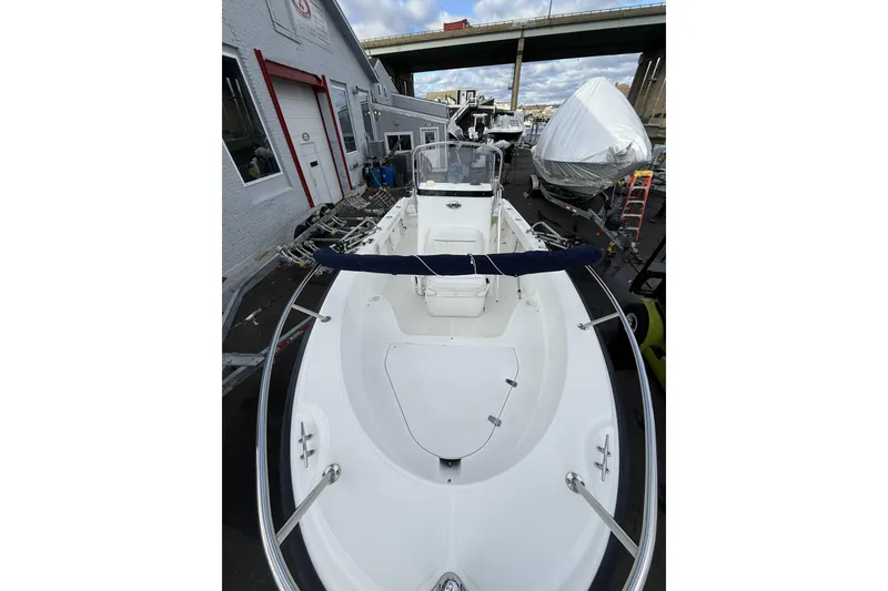 Slide: The Image of 2004 Boston Whaler 190 Nantucket boat docked near a warehouse under a bridge. - 5