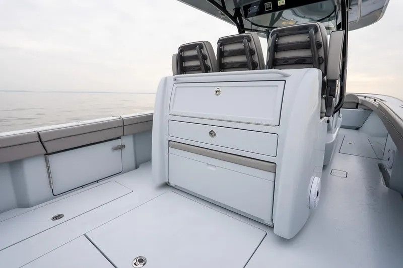 Slide: The Image of 2023 Valhalla Boatworks V-33 interior with seating and storage on calm water. - 12