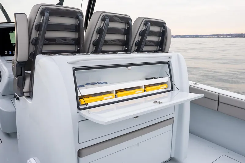 Slide: The Image of 2023 Valhalla Boatworks V-33 interior with storage compartment and seating on calm water. - 14