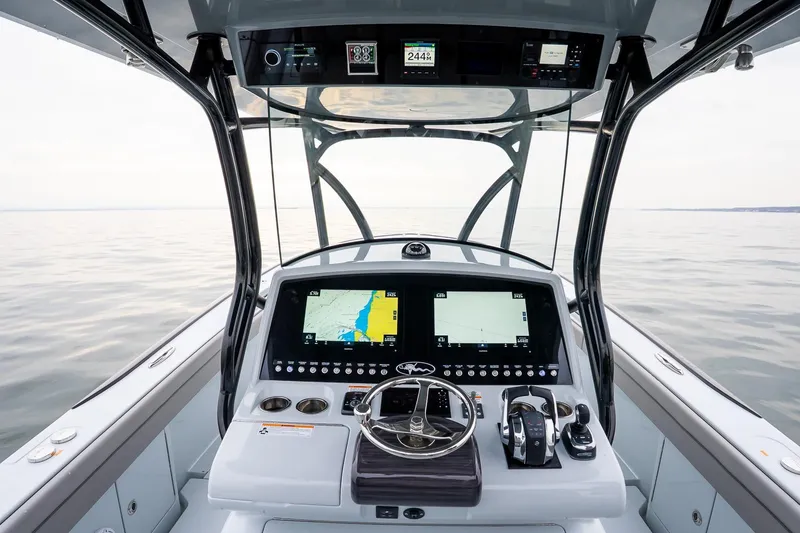 Slide: The Image of 2023 Valhalla Boatworks V-33 helm with advanced navigation displays on calm water. - 19