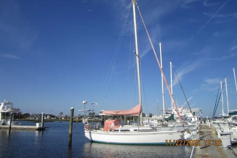 Slide: The Image of 1986 Catalina 30 MkII sailboat docked at marina under clear blue sky. - 10