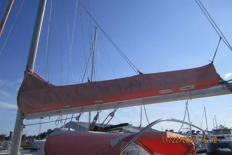 Slide: The Image of 1986 Catalina 30 MkII sailboat with red sail cover, docked under clear blue sky. - 16