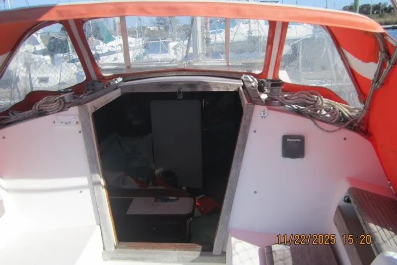 Slide: The Image of 1986 Catalina 30 MkII sailboat cockpit with orange canopy and open cabin entrance. - 26
