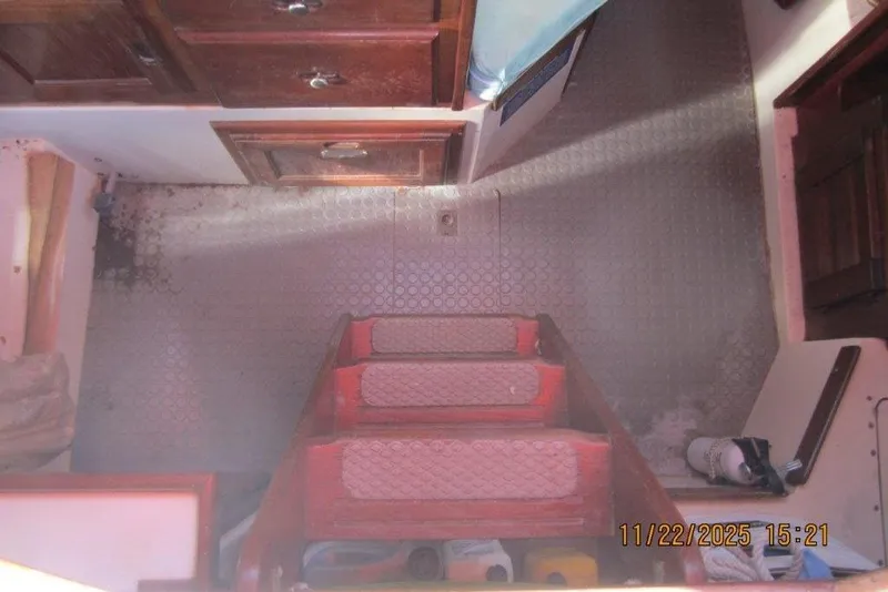 Slide: The Image of Interior of 1986 Catalina 30 MkII sailboat with wooden steps and storage cabinets. - 29