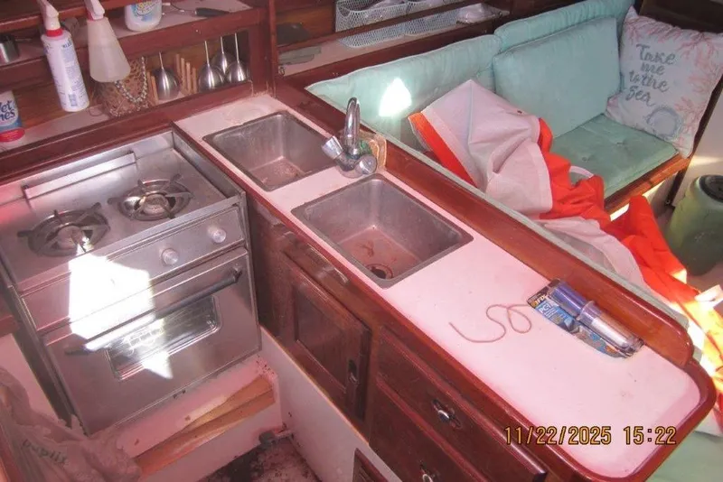 Slide: The Image of 1986 Catalina 30 MkII yacht interior with kitchen, stove, sink, and seating area. - 30
