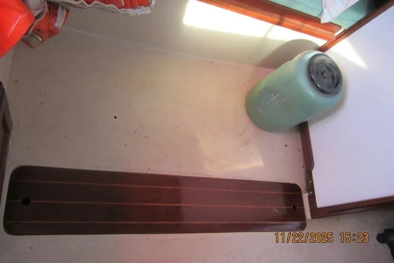 Slide: The Image of Interior of 1986 Catalina 30 MkII sailboat with wooden floorboard and green container. - 37