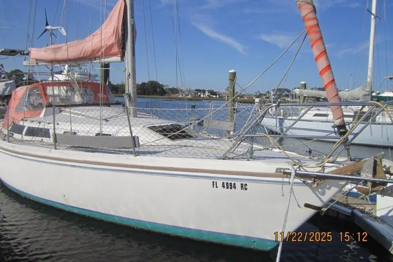 Slide: The Image of 1986 Catalina 30 MkII sailboat docked in marina, featuring orange sail cover. - 4