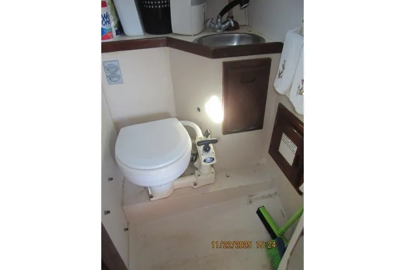 Slide: The Image of 1986 Catalina 30 MkII boat bathroom with toilet, sink, and storage cabinets. - 43