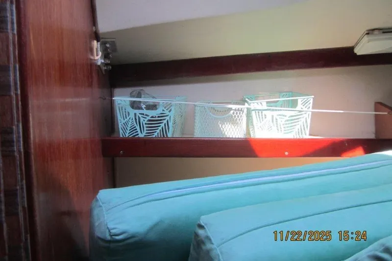 Slide: The Image of Interior of 1986 Catalina 30 MkII with teal cushions and storage baskets on a shelf. - 45