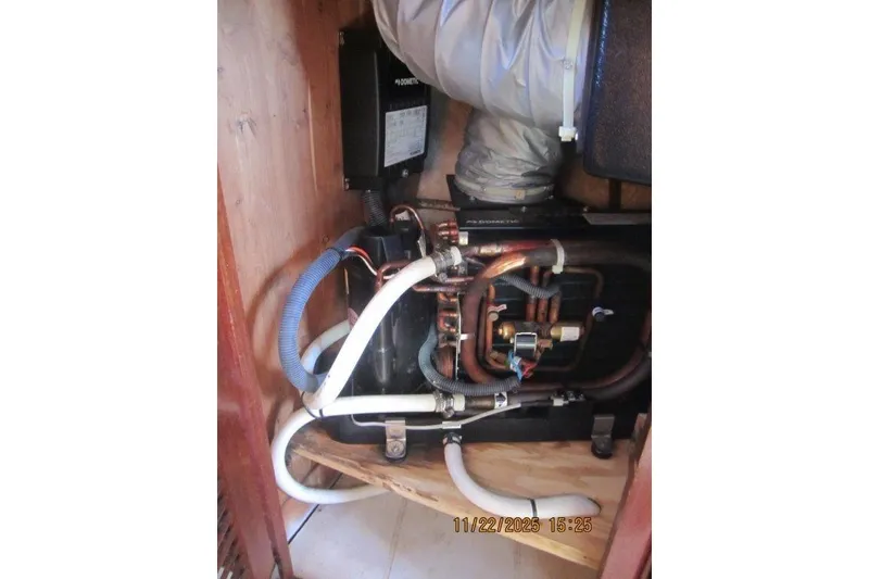Slide: The Image of Engine compartment of a 1986 Catalina 30 MkII sailboat, showing mechanical components and hoses. - 49