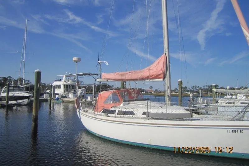 Slide: The Image of Catalina 30 MkII sailboat from 1986 docked in a marina under a clear blue sky. - 5