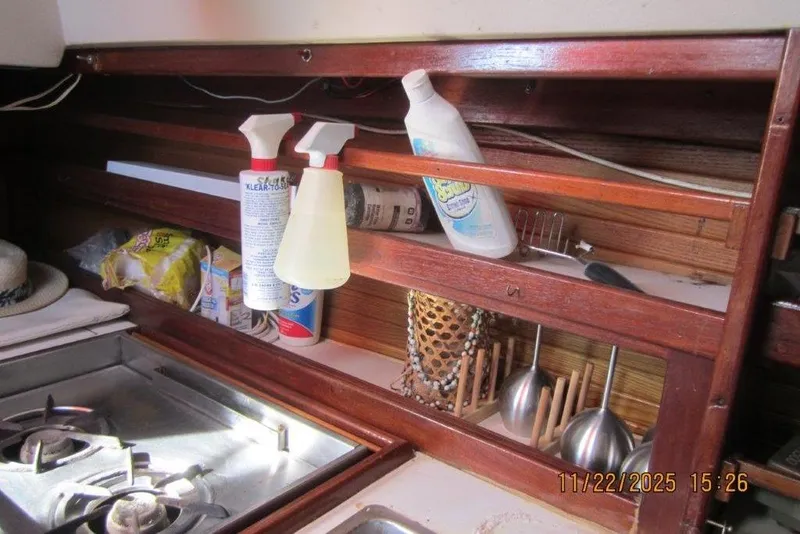 Slide: The Image of Galley of 1986 Catalina 30 MkII with stove, cleaning supplies, and utensils. - 55