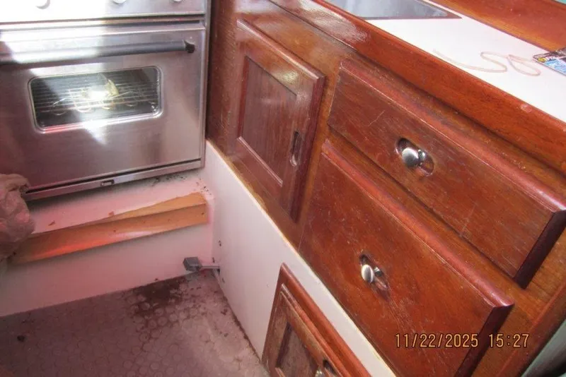 Slide: The Image of Interior of 1986 Catalina 30 MkII sailboat with wooden cabinetry and stainless steel oven. - 60