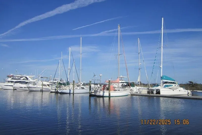 Slide: The Image of Boats docked at a marina under a clear blue sky, featuring a 1986 Catalina 30 MkII sailboat. - 67