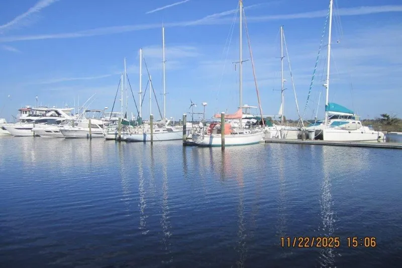 Slide: The Image of Boats docked at a marina, featuring a 1986 Catalina 30 MkII sailboat. - 68