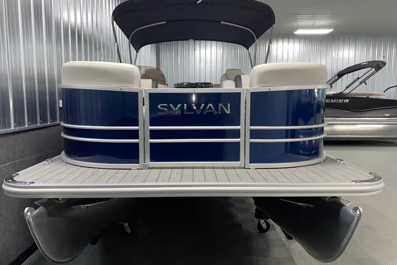 Slide: The Image of 2026 Sylvan Mirage 8522 CLZ DH pontoon boat in showroom, blue exterior, sleek design. - 14