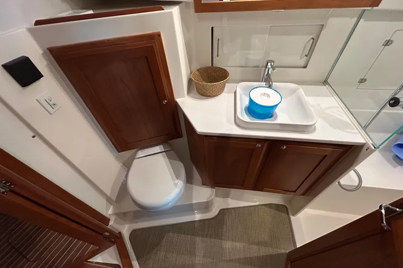 Slide: The Image of 2023 Back Cove 39O yacht bathroom with wooden cabinets, sink, and toilet. - 44