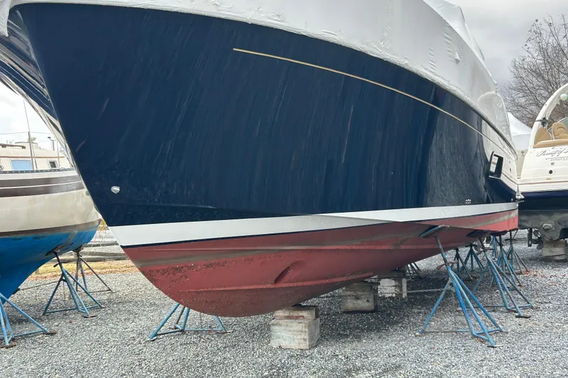 Slide: The Image of 2023 Back Cove 39O boat on stands, flag blue hull, red bottom, outdoor storage. - 5