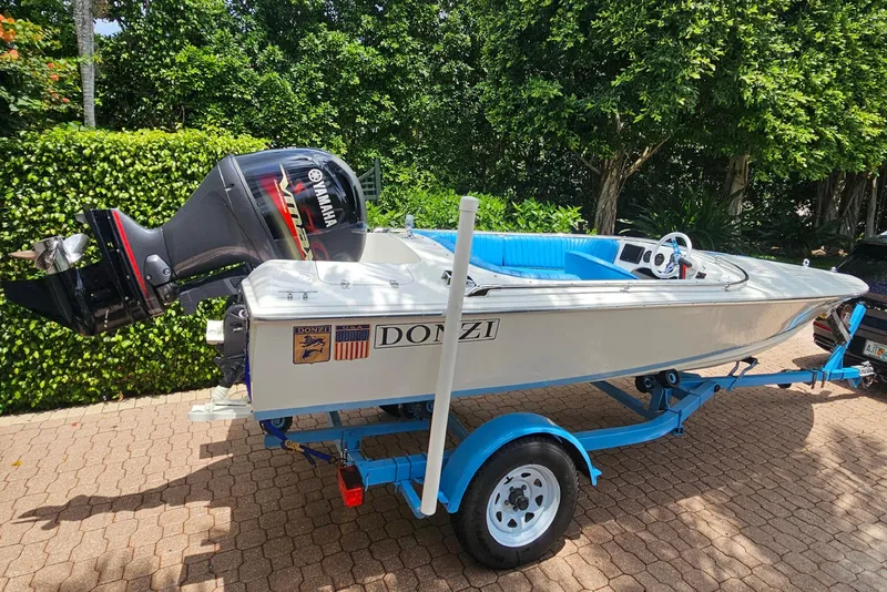 Slide: The Image of 1972 Donzi Sweet 16 Baby boat on trailer, featuring Yamaha outboard motor, surrounded by greenery. - 2