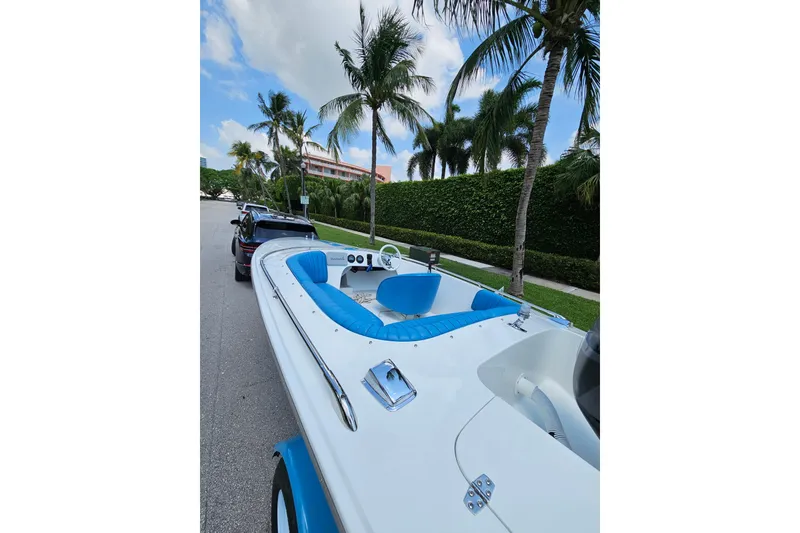 Slide: The Image of 1972 Donzi Sweet 16 Baby boat with blue interior, parked on a palm-lined street. - 5