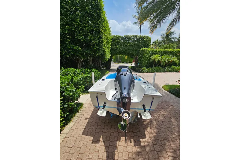 Slide: The Image of 1972 Donzi Sweet 16 Baby boat on a sunny driveway, surrounded by lush greenery. - 8