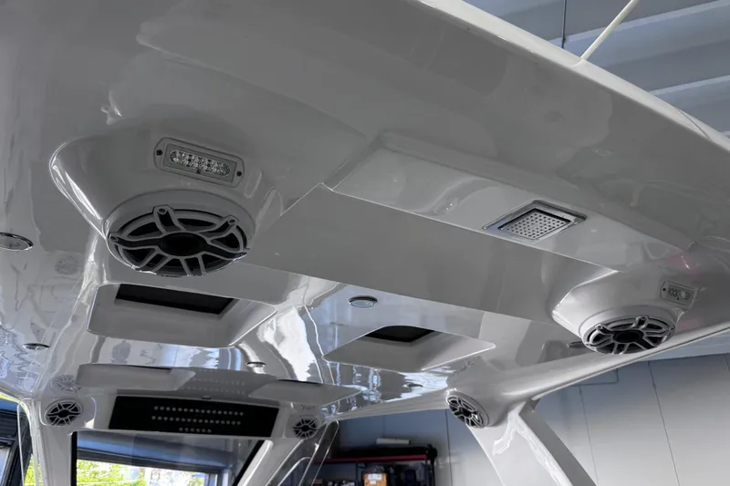 Slide: The Image of 2024 Deep Impact 399 Sport boat interior with white cushioned seating and storage compartments. - 20