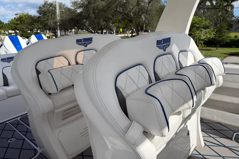 Slide: The Image of Luxury seating on 2024 Deep Impact 399 Sport boat, featuring white upholstery and blue accents. - 31