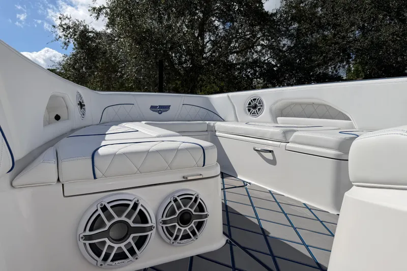Slide: The Image of 2024 Deep Impact 399 Sport boat interior with white seating and built-in speakers. - 33