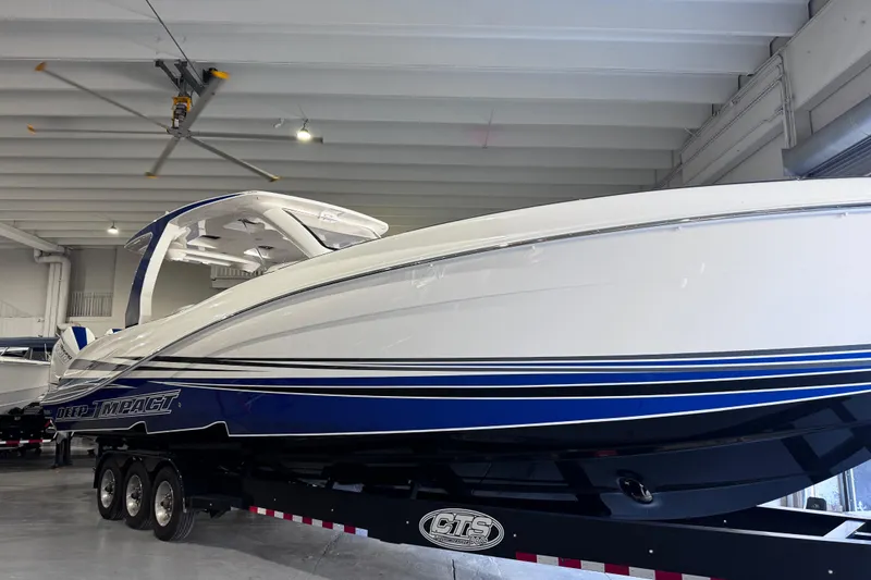 Slide: The Image of 2024 Deep Impact 399 Sport boat on trailer, sleek design, white and blue accents. - 5