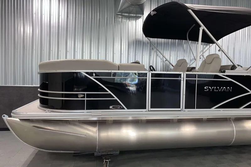 Slide: The Image of 2026 Sylvan Mirage 8522 LZ pontoon boat in a sleek indoor showroom. - 13