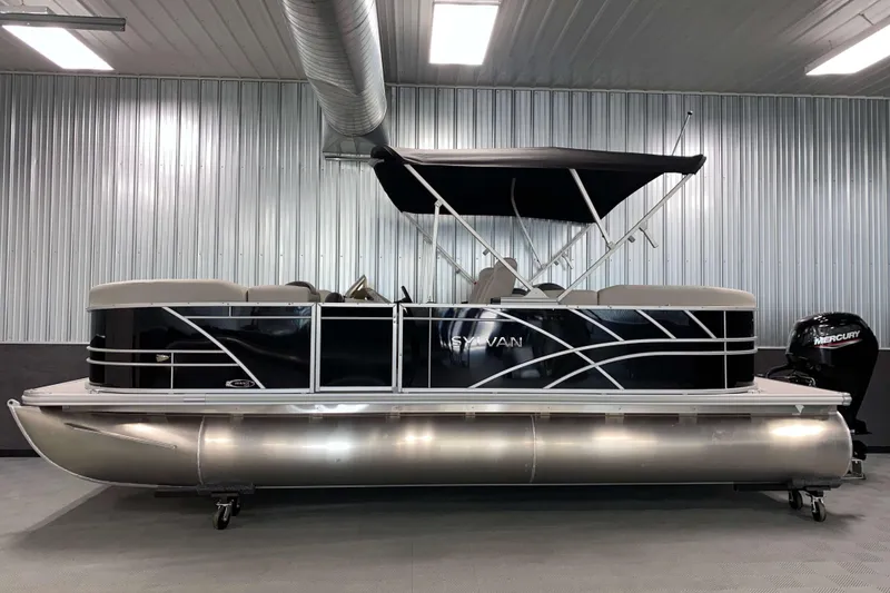 Slide: The Image of 2026 Sylvan Mirage 8522 LZ pontoon boat in a modern indoor showroom. - 14